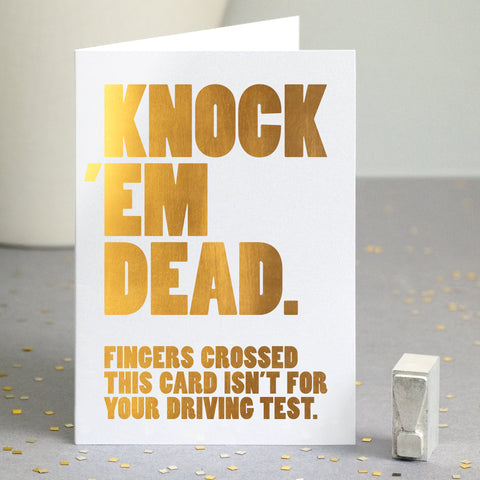 A funny gold foiled card with the text 'knock 'em dead, fingers crossed this card isn't for your driving test'.