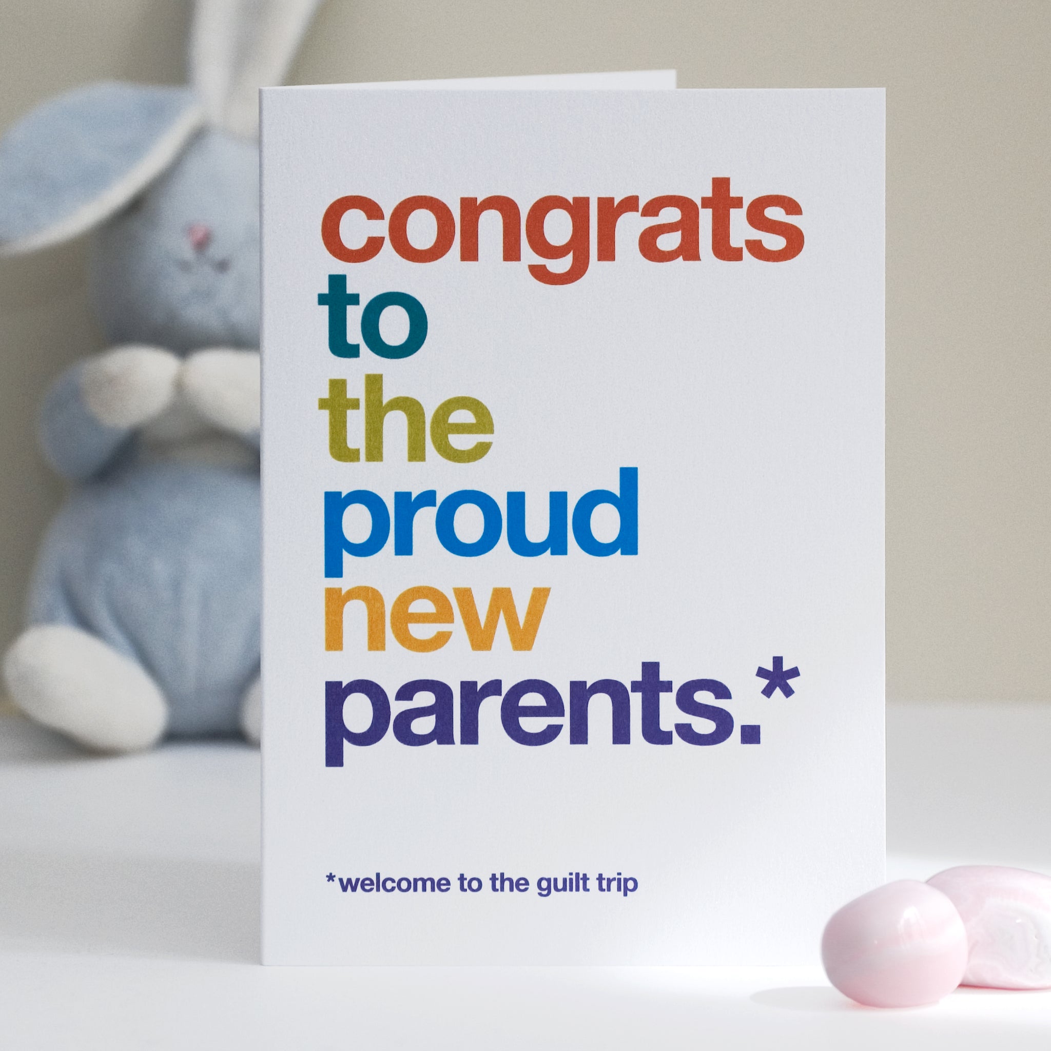 A funny new baby card saying 'congrats to the proud new parents, welcome to the guilt trip'.