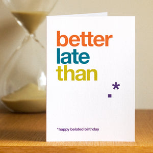 A funny belated birthday card saying 'better late than'. The word never is missing from the design.