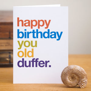 A funny greetings card saying 'happy birthday you old duffer' in colourful typography.