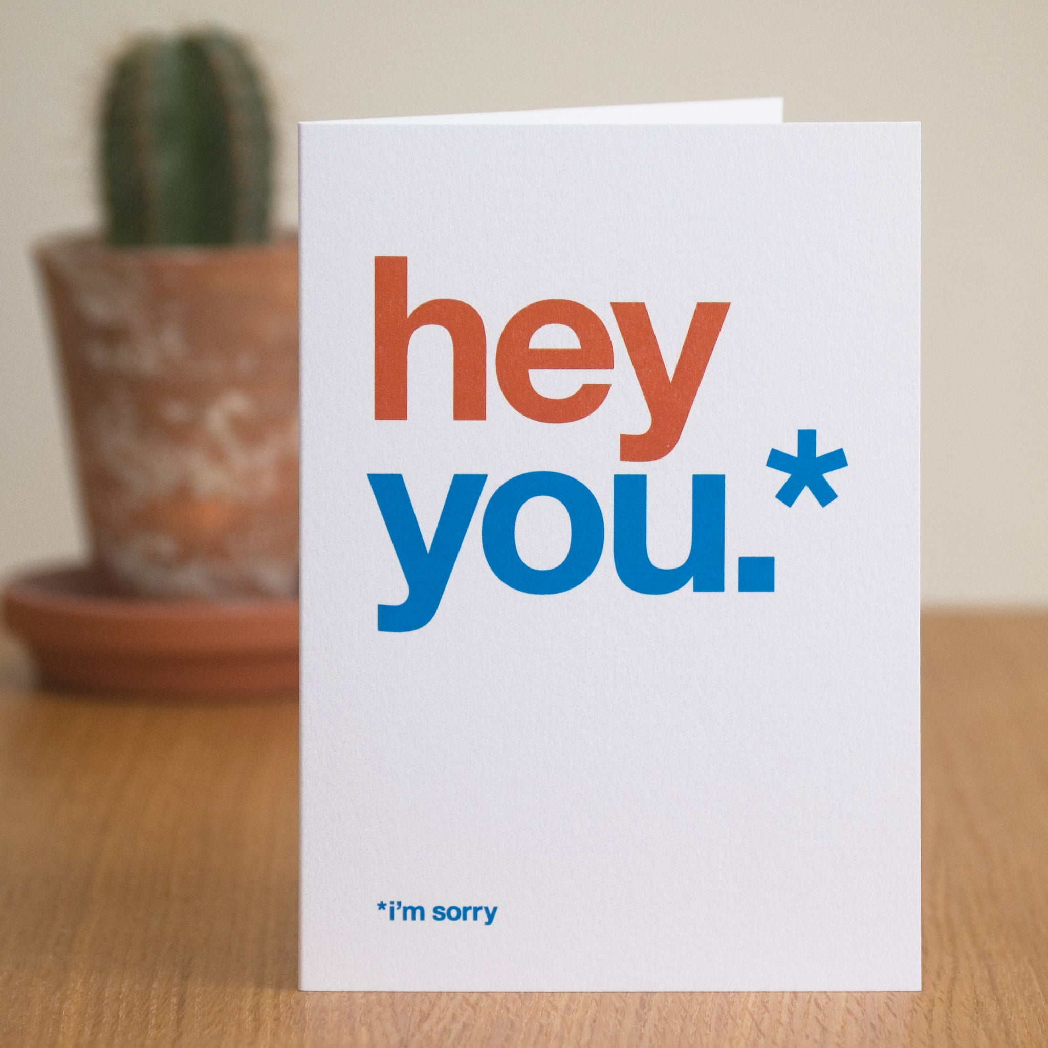 A greetings card saying 'hey you' in large letters and then 'i'm sorry' in small letters underneath.