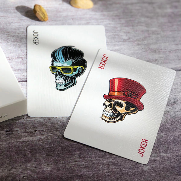 Close up of tattoo style skull illustrations on playing card jokers