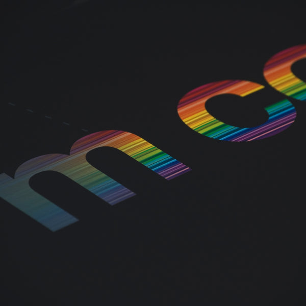 Close up detail of rainbow colours running through words on a typographic print
