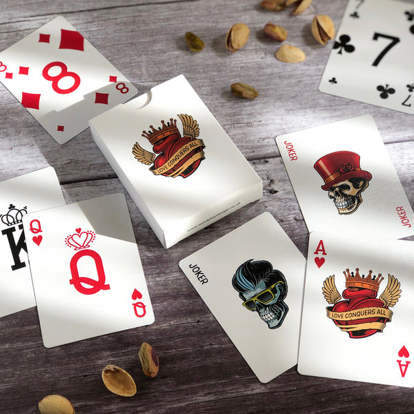 A pack of tattoo illustrated playing cards spread across a table